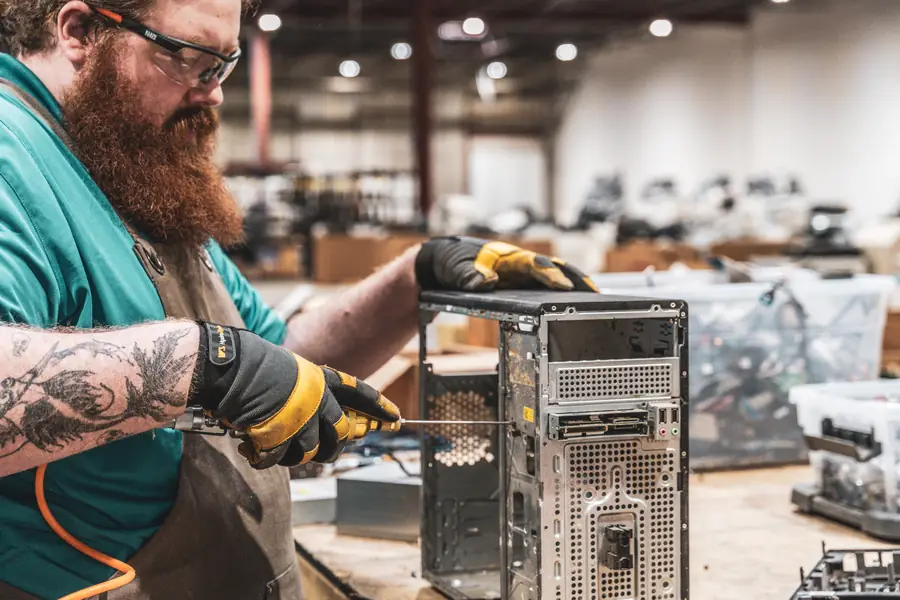 A technician taking apart a computer tower